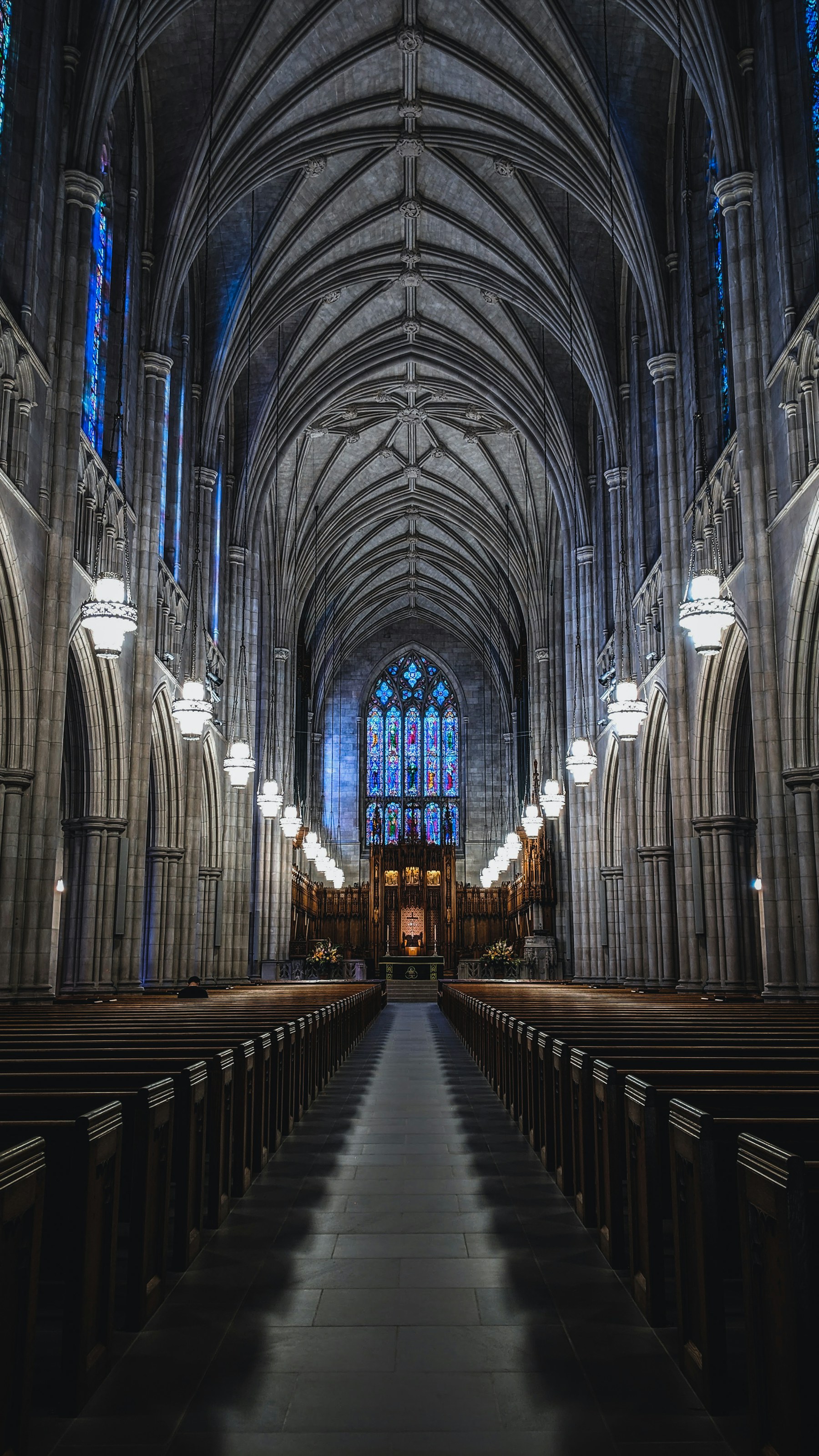 Interior of Duke Chapel in Durham, North Carolina, with vaulted stone arches and stained glass.